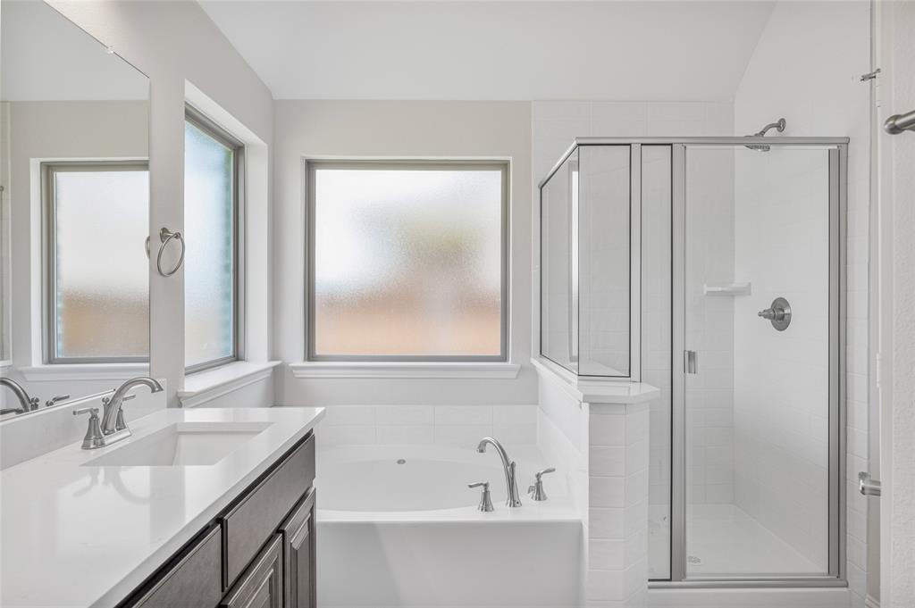 14566 Helena Street Pilot Point, TX 76258 - Photo 19 of 37 a bathroom with a tub a sink and mirror