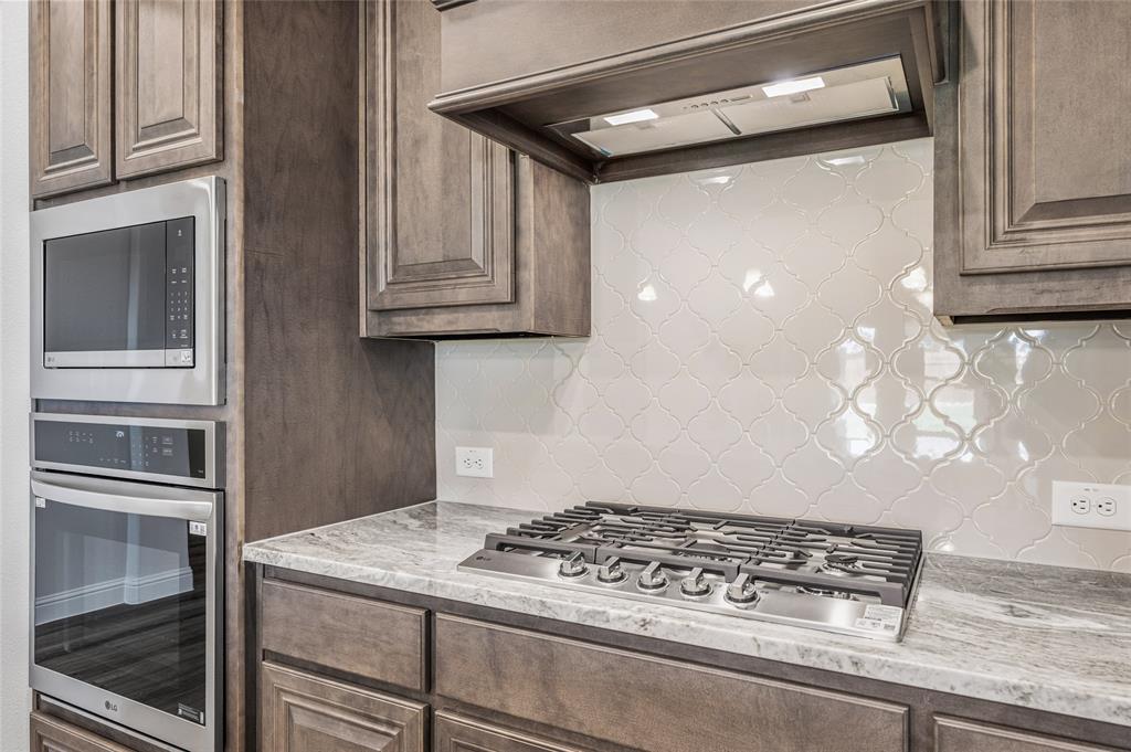 14566 Helena Street Pilot Point, TX 76258 - Photo 9 of 37 a kitchen with stainless steel appliances granite countertop a refrigerator and a stove