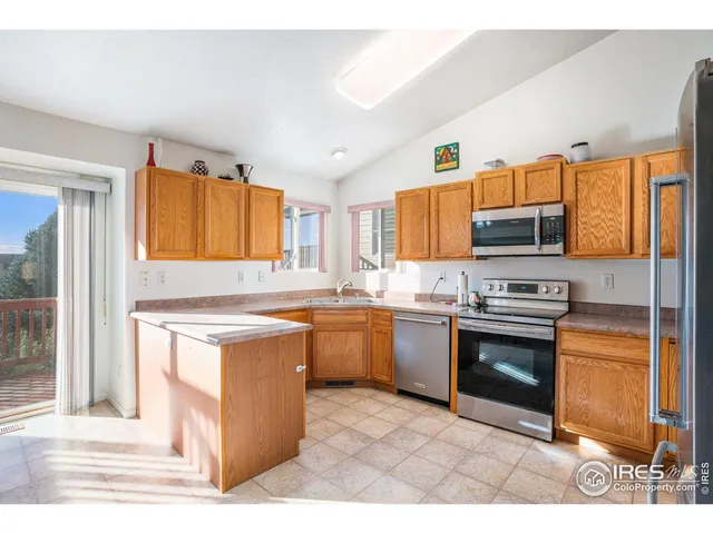 a kitchen with stainless steel appliances granite countertop a stove top oven a sink a counter space and cabinets