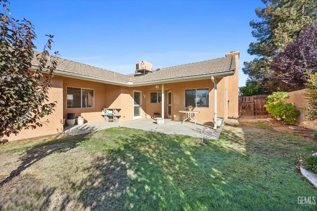 a view of a house with backyard and a tree