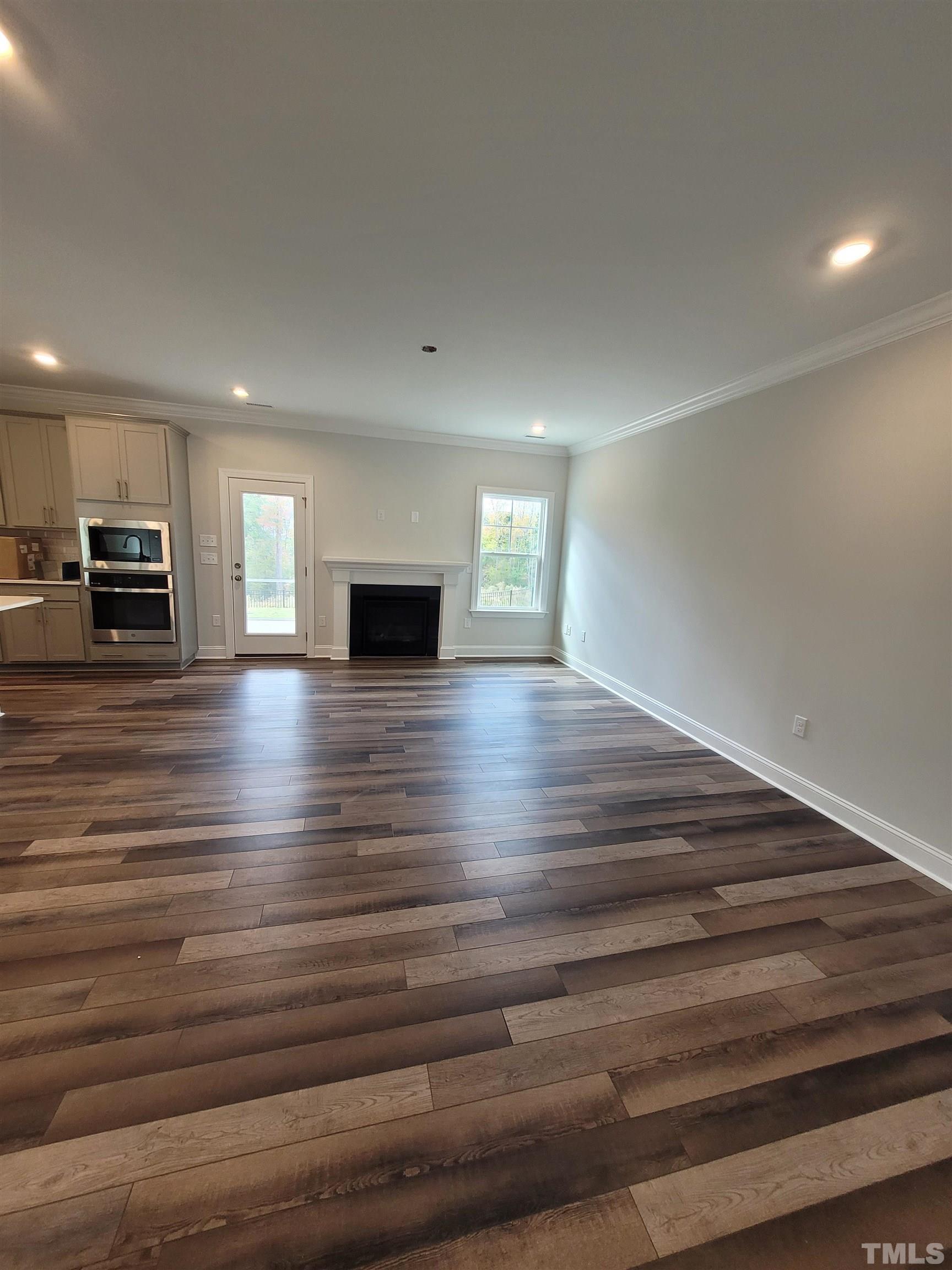 124 Trailing Bluff Way Garner, NC 27529 - Photo 12 of 21 a view of an empty room with wooden floor and a window