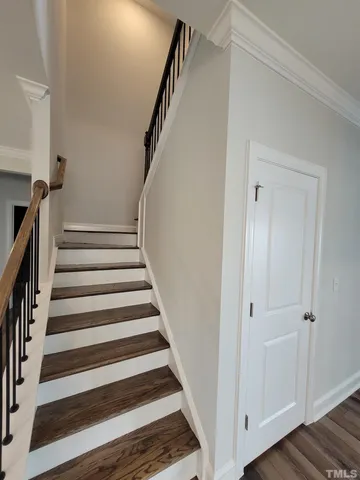 a view of staircase with wooden floor and white walls