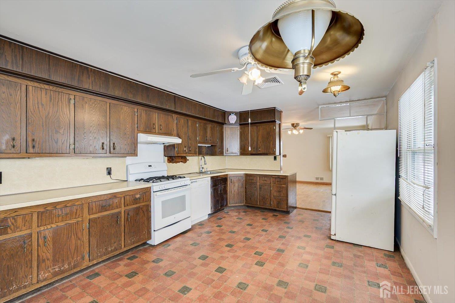 27 Stiles Road Edison, NJ 08817 - Photo 9 of 20 a kitchen with a sink a refrigerator and cabinets