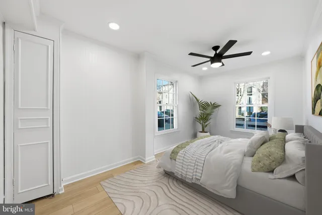 a bedroom with a large bed chandelier and a window