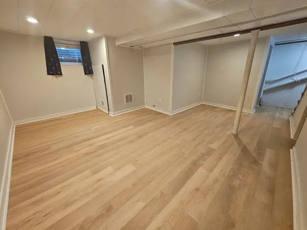 an empty room with a wooden floor and windows