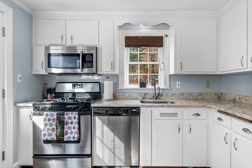 61 Ledgewood Road Dedham, MA 02026 - Photo 3 of 23 a kitchen with stainless steel appliances granite countertop a stove microwave and cabinets