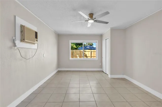 an empty room with windows and fan