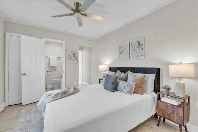 a bedroom with a bed and a lamp on a dresser