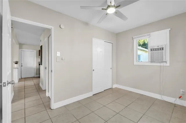 an empty room with fan and windows
