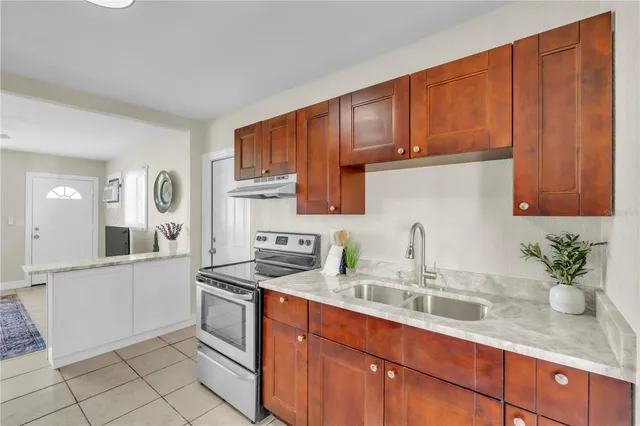a kitchen with stainless steel appliances granite countertop a sink stove and cabinets