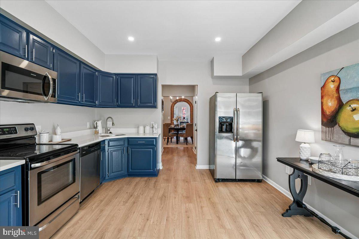 817 4th Street Northeast Washington, DC 20002 - Photo 14 of 40 a kitchen with granite countertop wooden floors a stove and a refrigerator