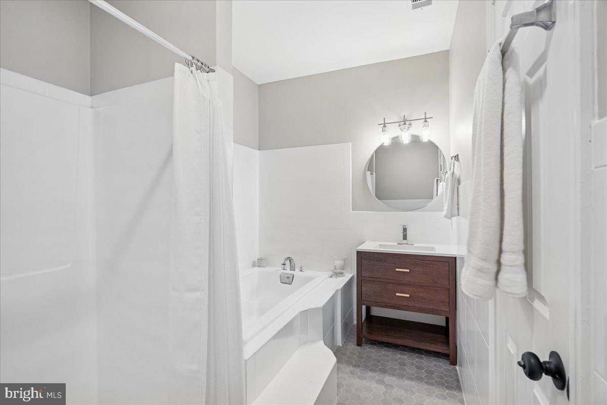 817 4th Street Northeast Washington, DC 20002 - Photo 23 of 40 a spacious bathroom with a double vanity sink a mirror and a bathtub