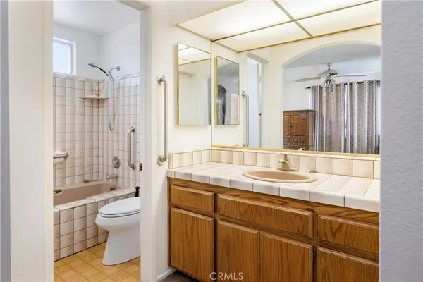 a bathroom with a granite countertop sink toilet mirror and shower