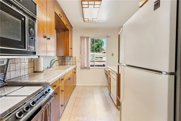 a view of a kitchen with a stove top oven a refrigerator and a sink
