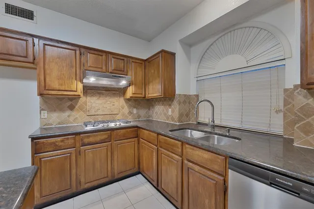 a kitchen with cabinets a sink and appliances