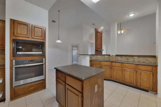 a kitchen with granite countertop a sink and cabinets