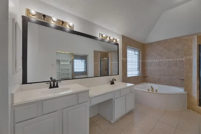 a bathroom with a double vanity sink a toilet a bathtub and shower