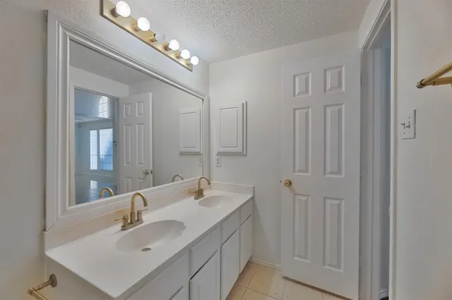 a bathroom with double vanity sink and a mirror