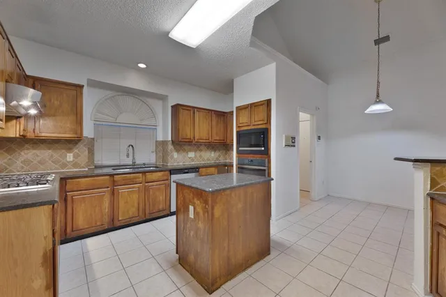 a kitchen with stainless steel appliances granite countertop a refrigerator and a sink