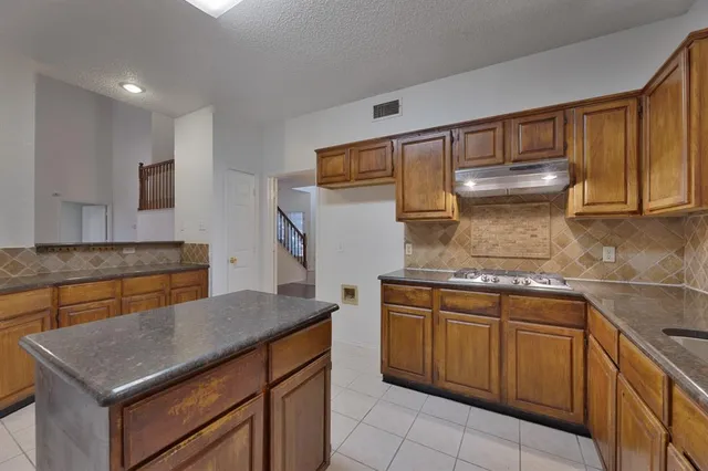 a kitchen with stainless steel appliances granite countertop a sink and a stove