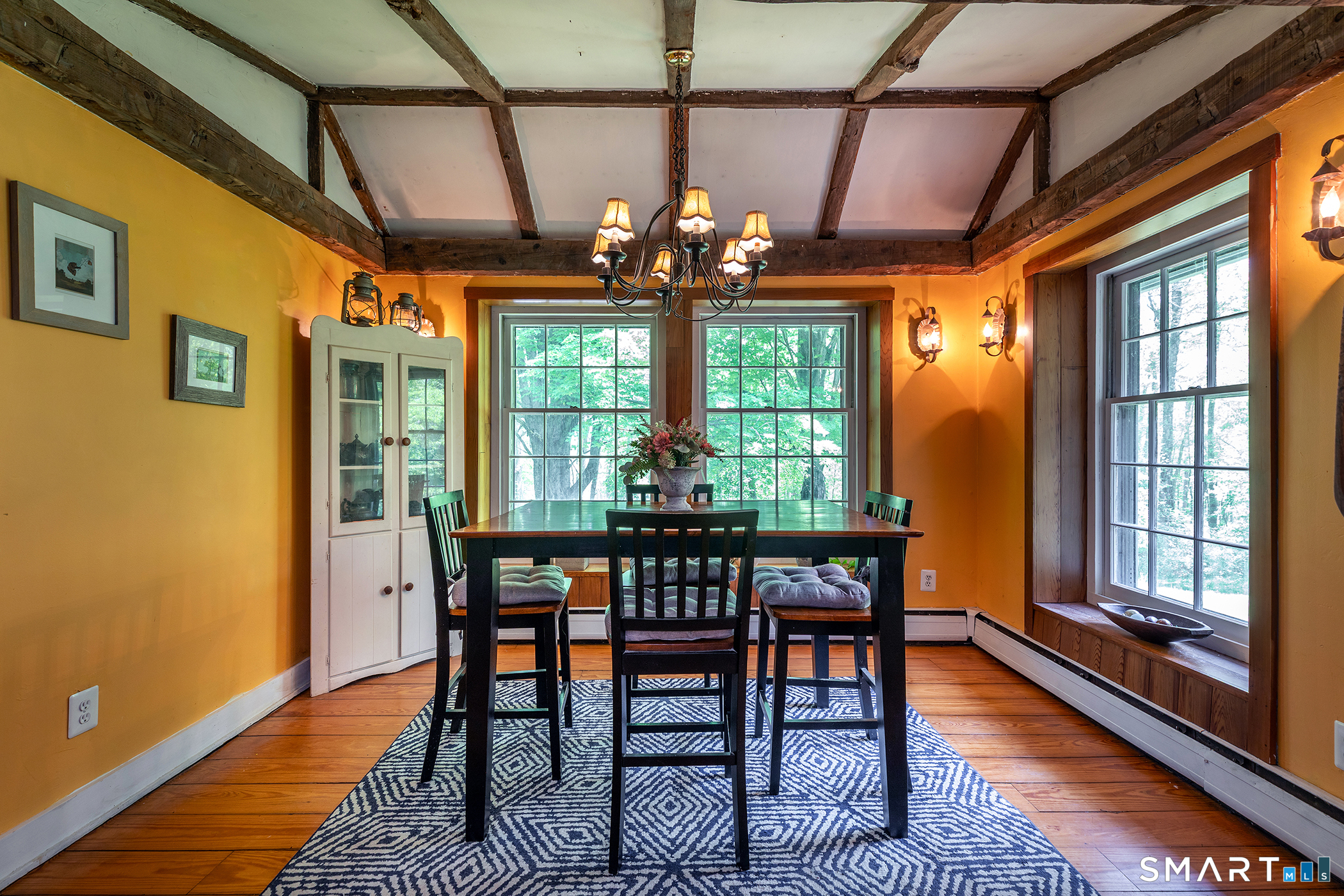 25 Bald Hill Road Kent, CT 06785 - Photo 6 of 38 Framed by cathedral ceilings, this stunning dining room brings the beauty of nature indoors through extra-large windows. The wide honey wood floors add rich character and warmth, creating an inviting space perfect for gathering.