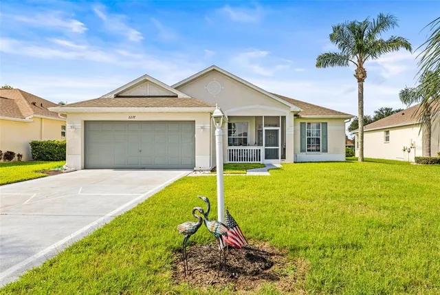 a view of a house with a yard and palm tree