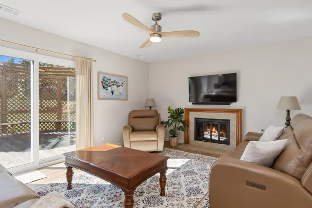 a living room with furniture a flat screen tv and a fireplace