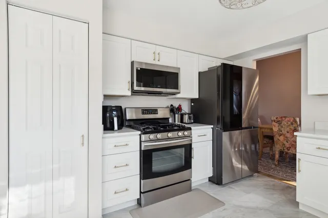 a kitchen with stainless steel appliances white cabinets and a stove