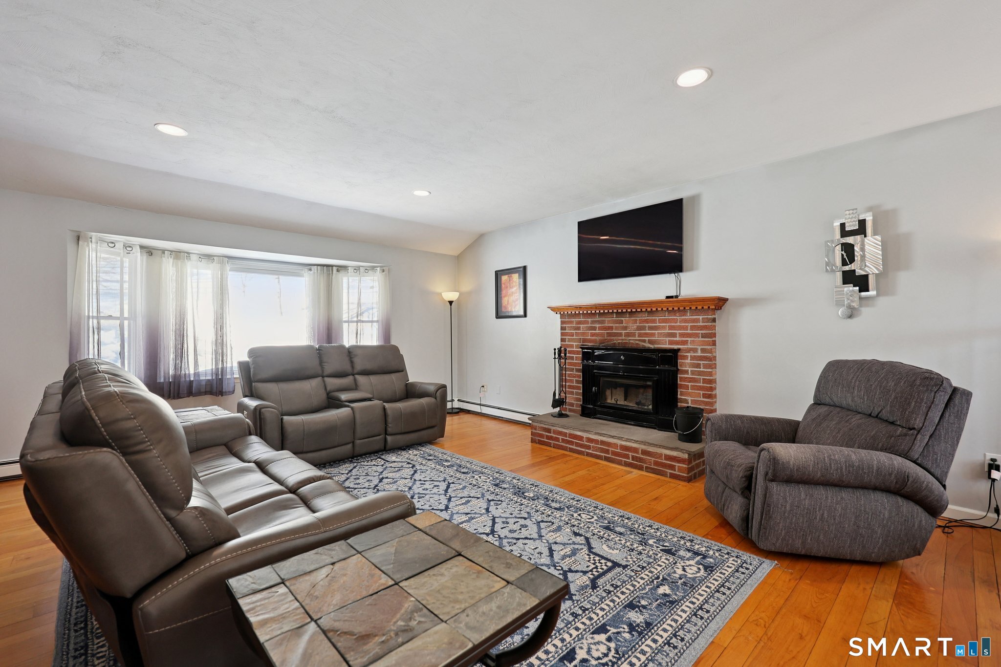 36 Bigelow Road New Fairfield, CT 06812 - Photo 3 of 37 Living room with a Regency Hampton H1500 wood burning fireplace insert.
