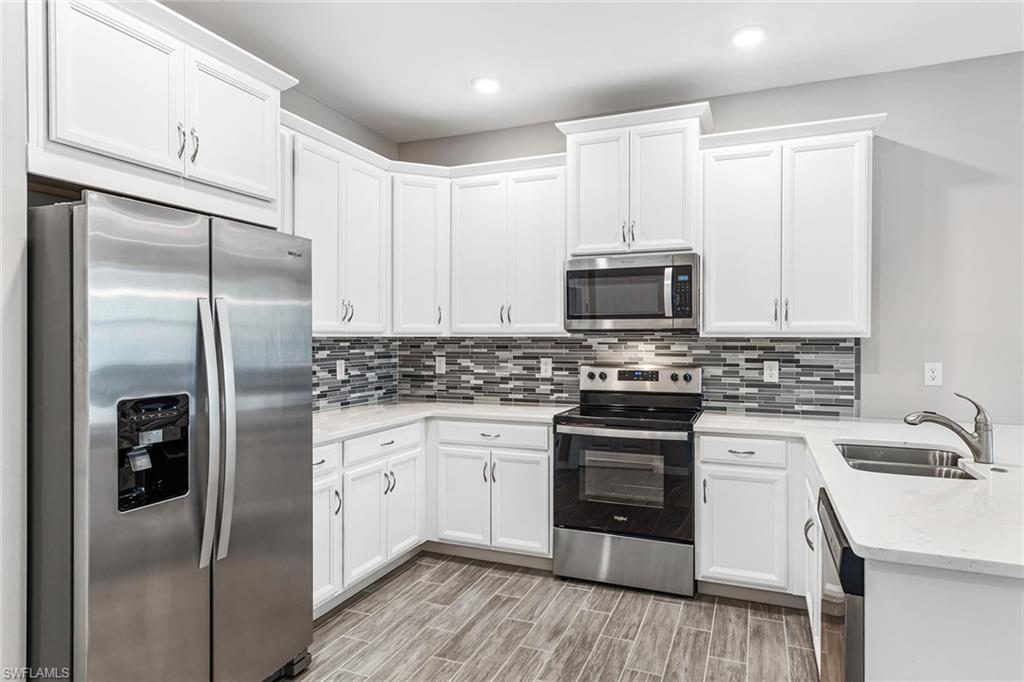 1252 Enbrook Loop Naples, FL 34114 - Photo 1 of 26 a kitchen with a sink stove and refrigerator