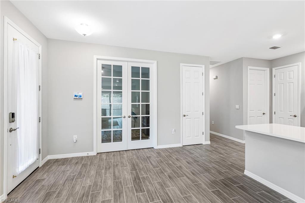 1252 Enbrook Loop Naples, FL 34114 - Photo 5 of 26 wooden floor in an empty room with a window