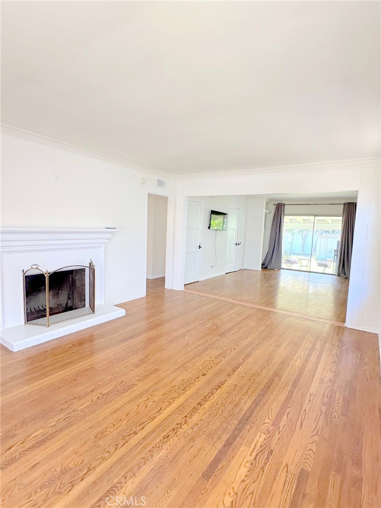 14722 Addison Street Sherman Oaks, CA 91403 - Photo 14 of 22 a view of empty room with wooden floor and fireplace