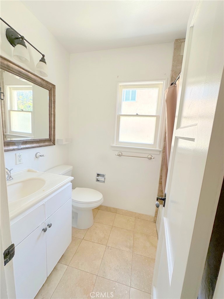 14722 Addison Street Sherman Oaks, CA 91403 - Photo 17 of 22 a bathroom with a toilet sink and mirror with window