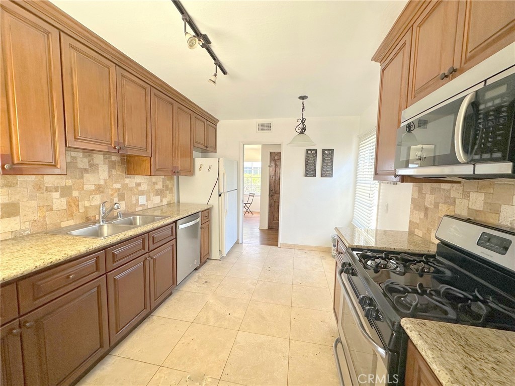 14722 Addison Street Sherman Oaks, CA 91403 - Photo 2 of 22 a kitchen with stainless steel appliances granite countertop a stove and a sink