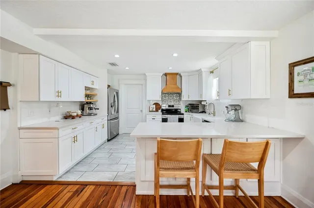 a kitchen with stainless steel appliances kitchen island granite countertop a refrigerator and microwave