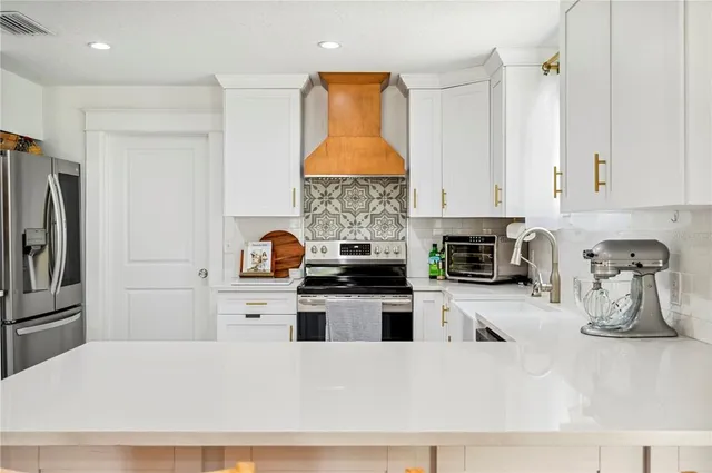 a kitchen with stainless steel appliances white cabinets and a refrigerator