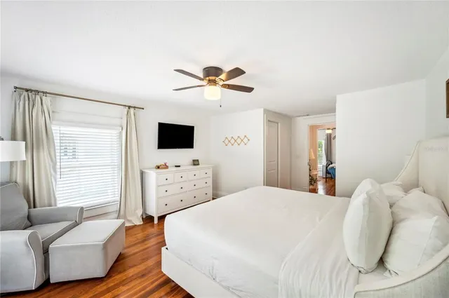 a spacious bedroom with a bed and a flat screen tv