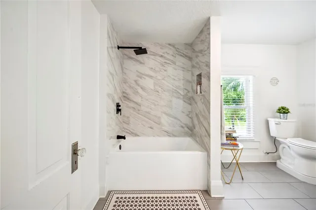 a bathroom with a bathtub sink mirror and toilet