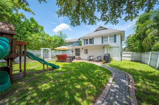 a view of a house with a backyard and a tree