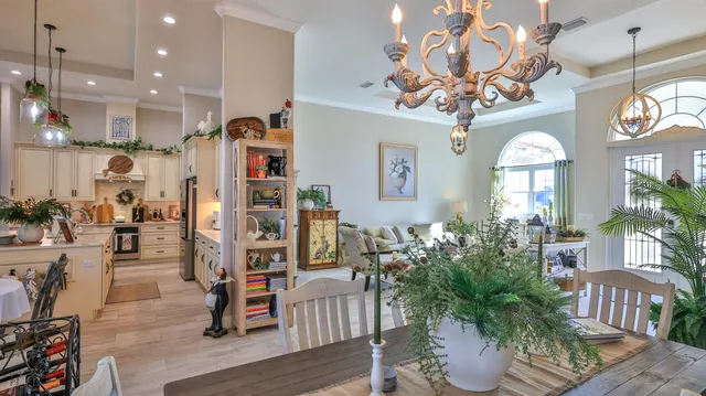 a view of a dining room and livingroom with furniture wooden floor a chandelier