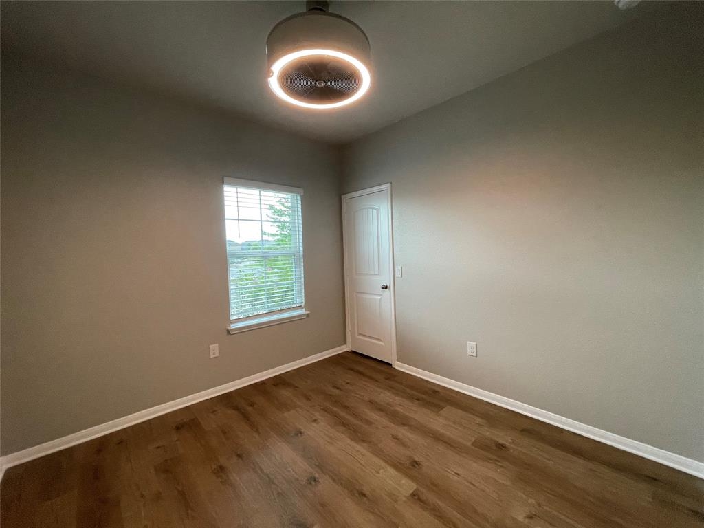 6717 Ranchito Drive Austin, TX 78744 - Photo 15 of 28 Secondary bedroom #1 features a spacious closet and abundant natural light with a modern light fixture.