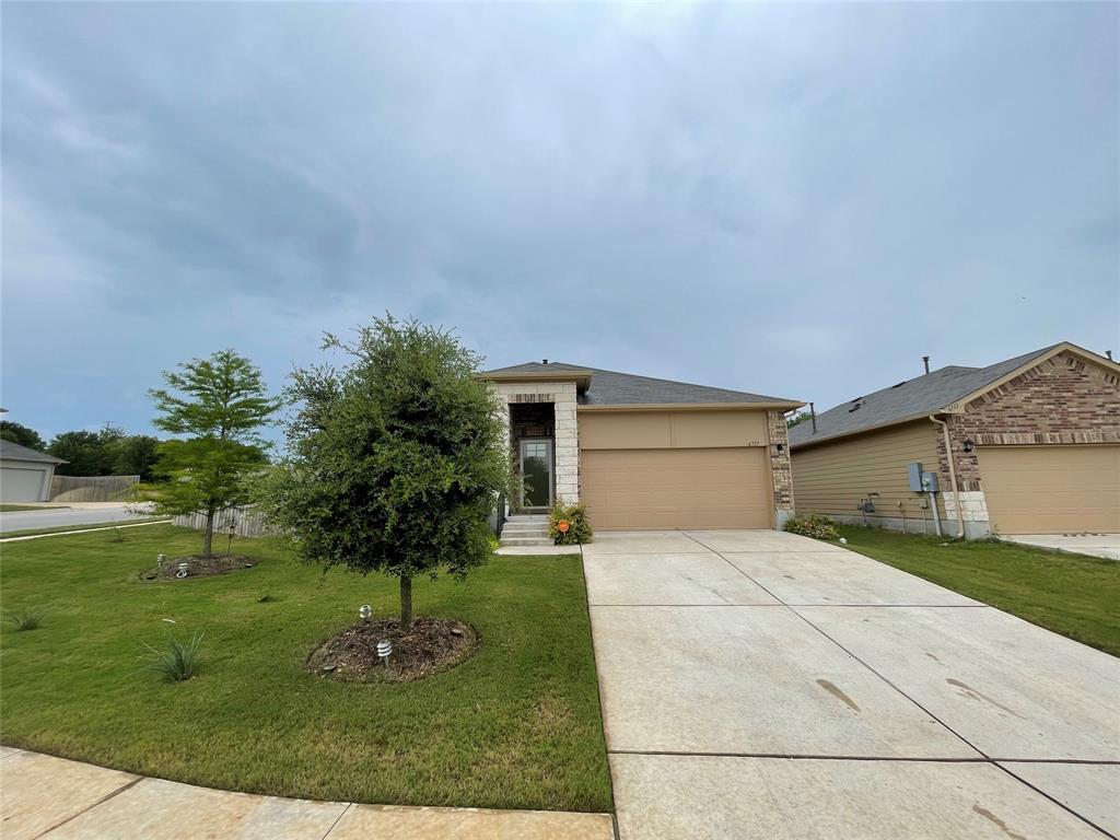 6717 Ranchito Drive Austin, TX 78744 - Photo 24 of 28 View of front of house featuring an attached garage, a front yard, and concrete driveway