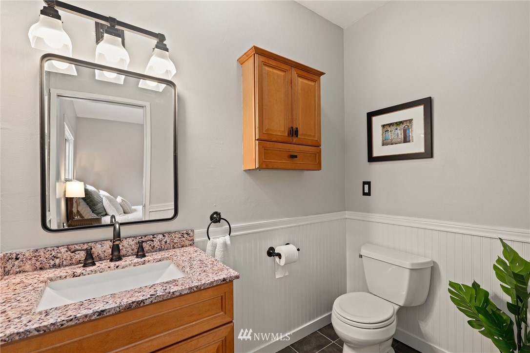 19128 Northeast Redmond Road Redmond, WA 98053 - Photo 17 of 35 a bathroom with a granite countertop toilet a sink and a mirror