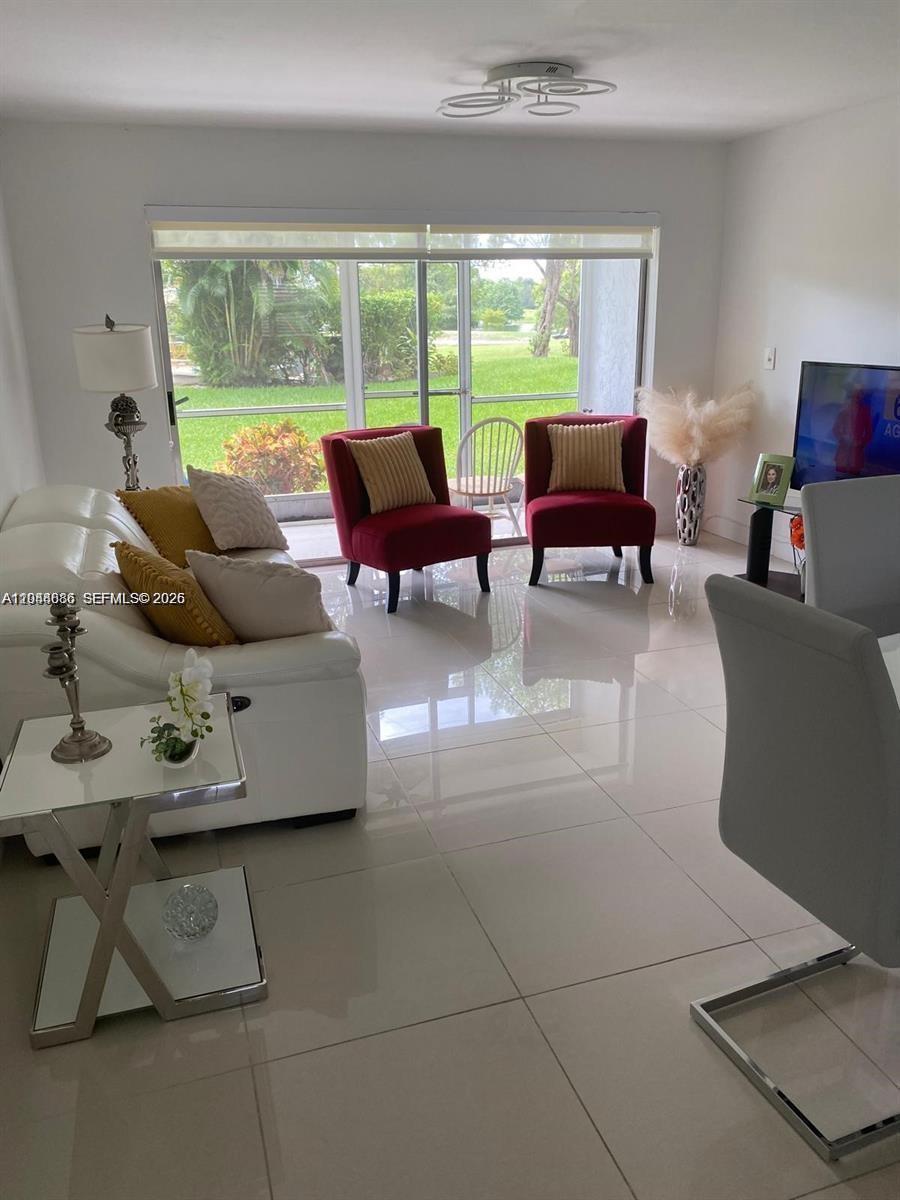 8838 West McNab Road, Unit 104 Tamarac, FL 33321 - Photo 1 of 23 a living room with furniture and a large window