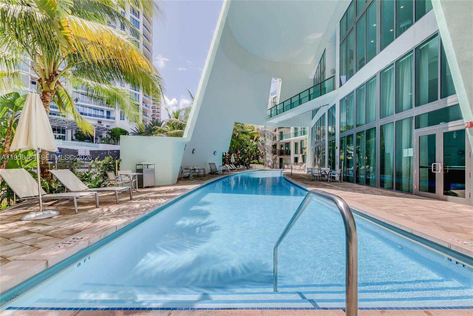 6000 Collins Avenue, Unit 112 Miami Beach, FL 33140 - Photo 49 of 53 a view of a swimming pool with potted plants