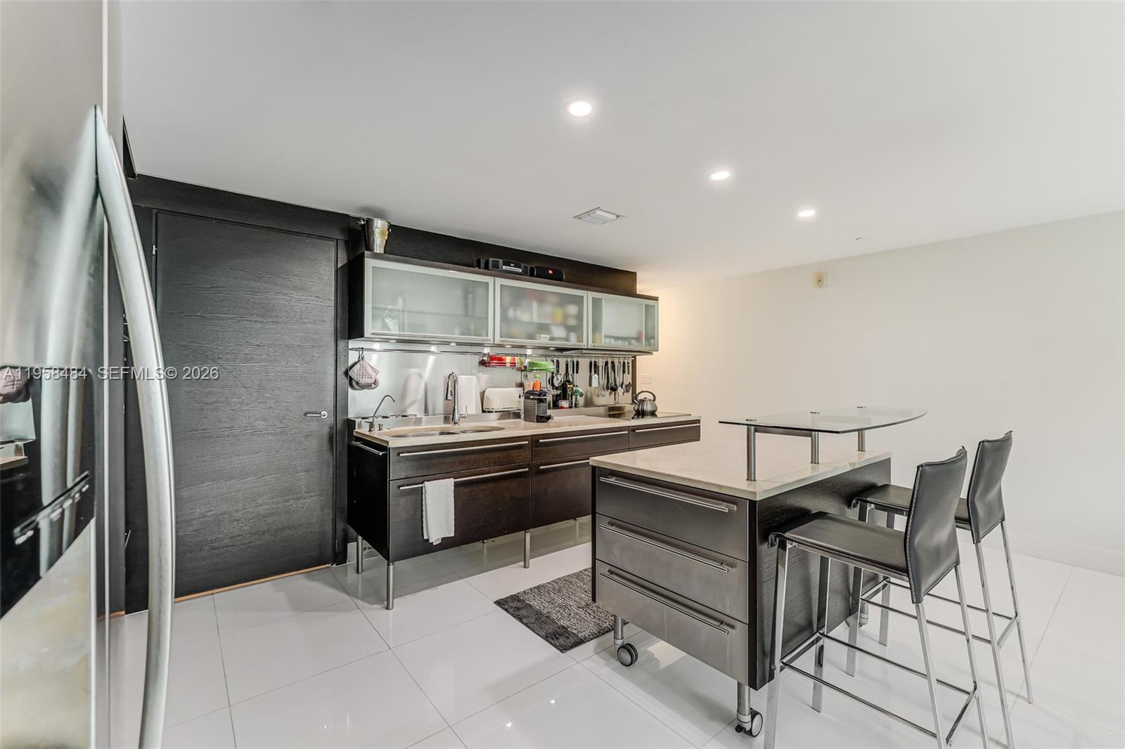 6000 Collins Avenue, Unit 112 Miami Beach, FL 33140 - Photo 10 of 53 a kitchen with stainless steel appliances granite countertop a sink and a refrigerator