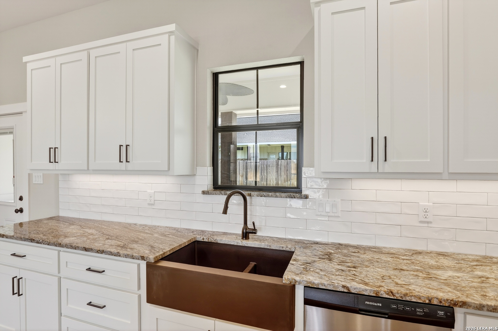 721 North Dickson Street Poth, TX 78147 - Photo 17 of 40 a kitchen with granite countertop a sink and a window