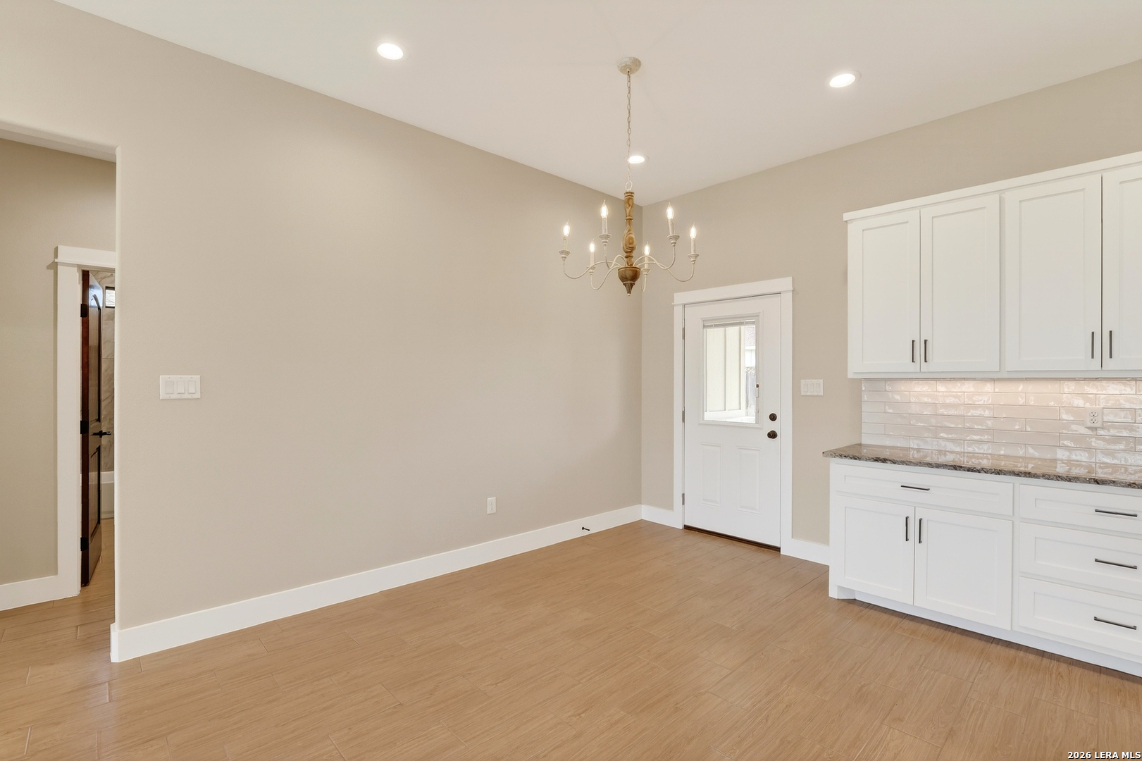 721 North Dickson Street Poth, TX 78147 - Photo 10 of 40 wooden floor in an empty room with a kitchen