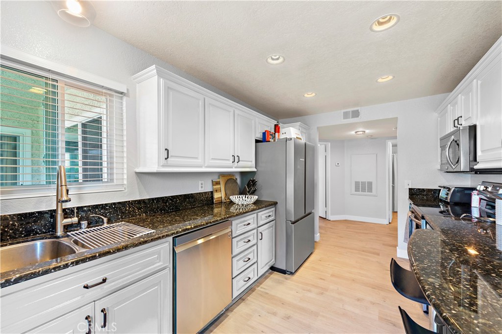 70 Corniche Drive, Unit A Dana Point, CA 92629 - Photo 26 of 58 a kitchen with granite countertop a sink a counter top space cabinets and stainless steel appliances