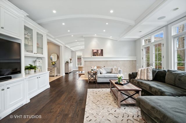 a living room with furniture a flat screen tv and kitchen view